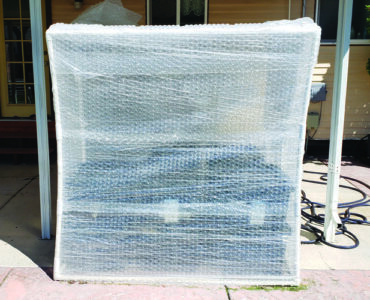 The entire square structure wrapped tightly with bubble wrap. The pvc frame is bowed slightly…